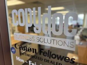 Photo of Copy Doc Business Solutions store front window sign and lettering.